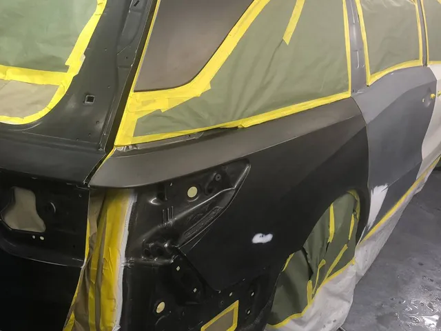 Dark SUV rear quarter panel masked for paint