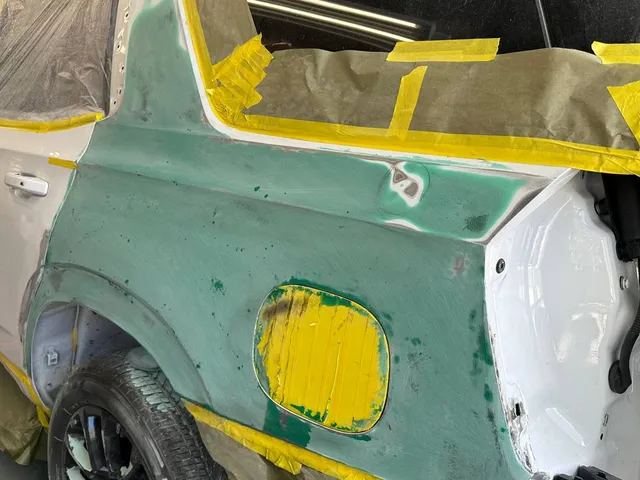 White SUV rear quarter panel with body filler shaped before paint
