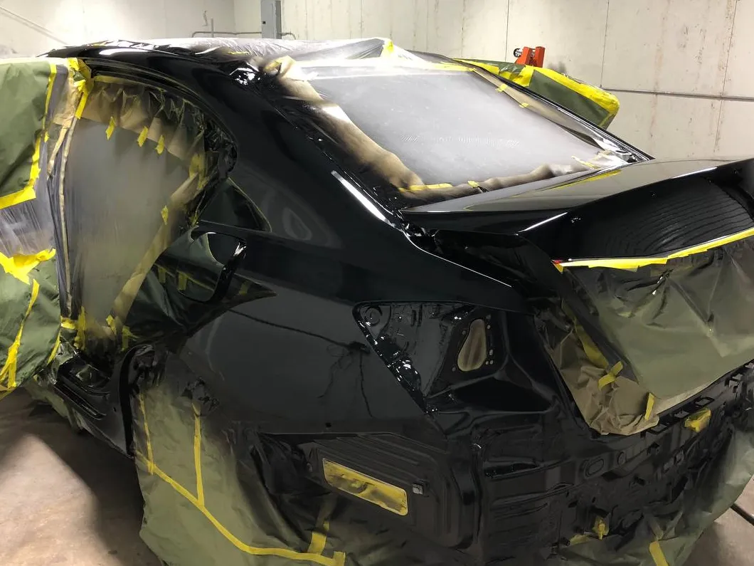 Black sedan with the rear end masked for refinishing