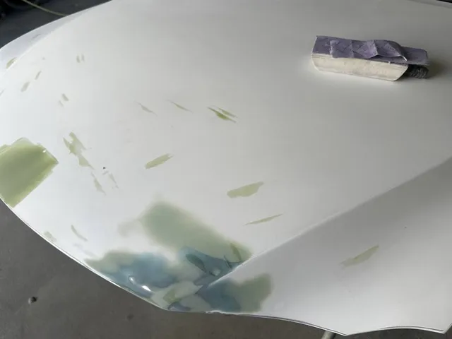 White hood being block-sanded after filler work
