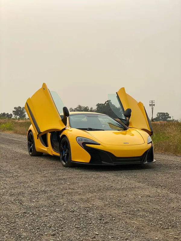 Yellow McLaren supercar with its doors open
