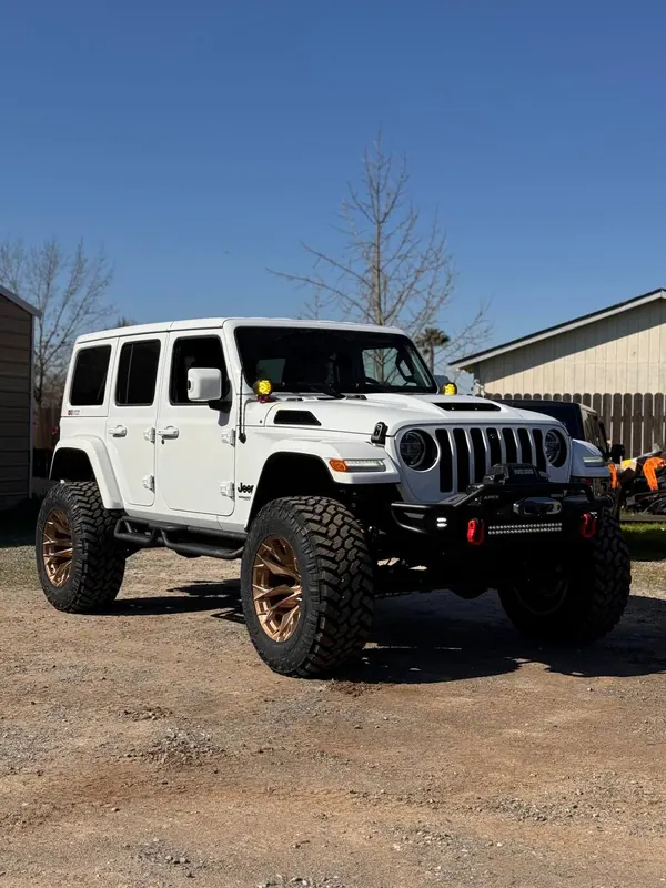 Lifted white Jeep Wrangler on bronze wheels